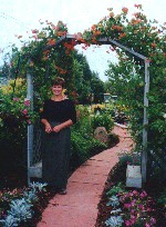 Brenda at her garden entrance framed by honeysuckle